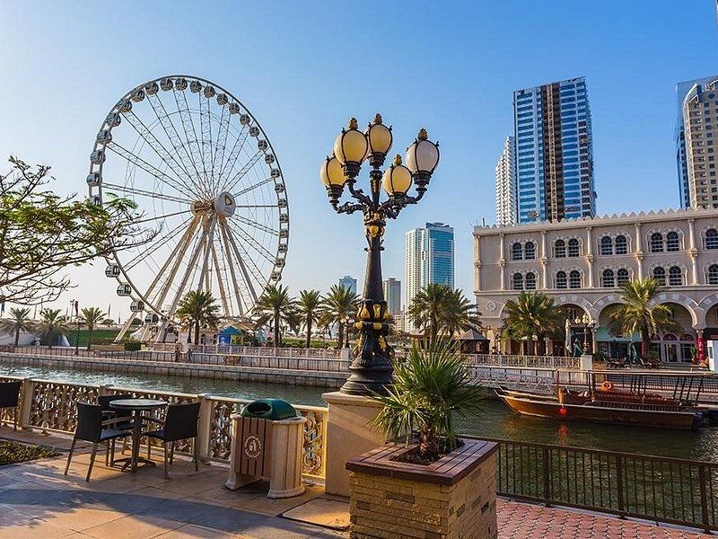 A waterfront promenade in Dubai Marina, with the Ain Dubai observation wheel beyond