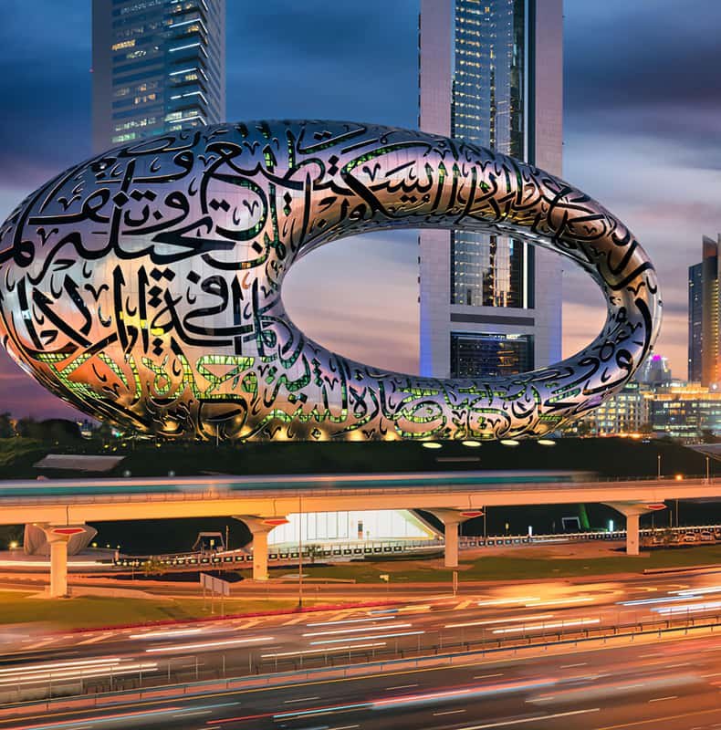 The Museum of the Future beside Sheikh Zayed Road, lit at dusk with traffic trails below