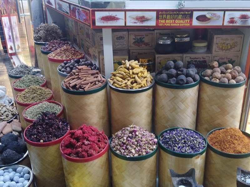 Open baskets of spices, dried rose buds and frankincense at a Dubai Spice Souk stall