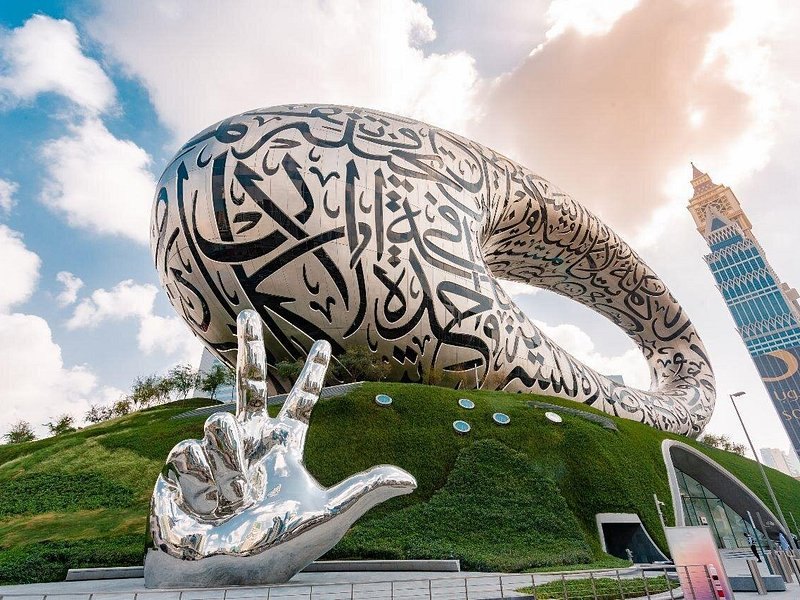 The mirrored hand sculpture on the lawn beside the Museum of the Future